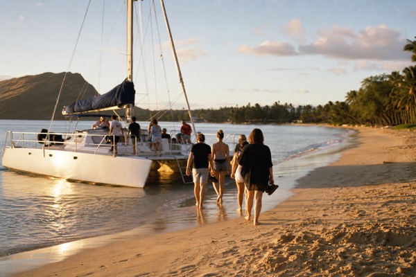Catamaran nosed onto the sand at Kaanapali Beach loading passengers with resorts behind